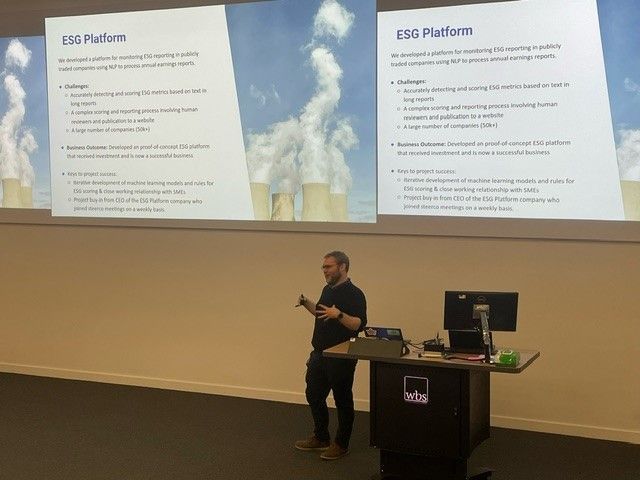 James stood at the front of a lecture theatre presenting a slide about an project he worked on for an ESG company.