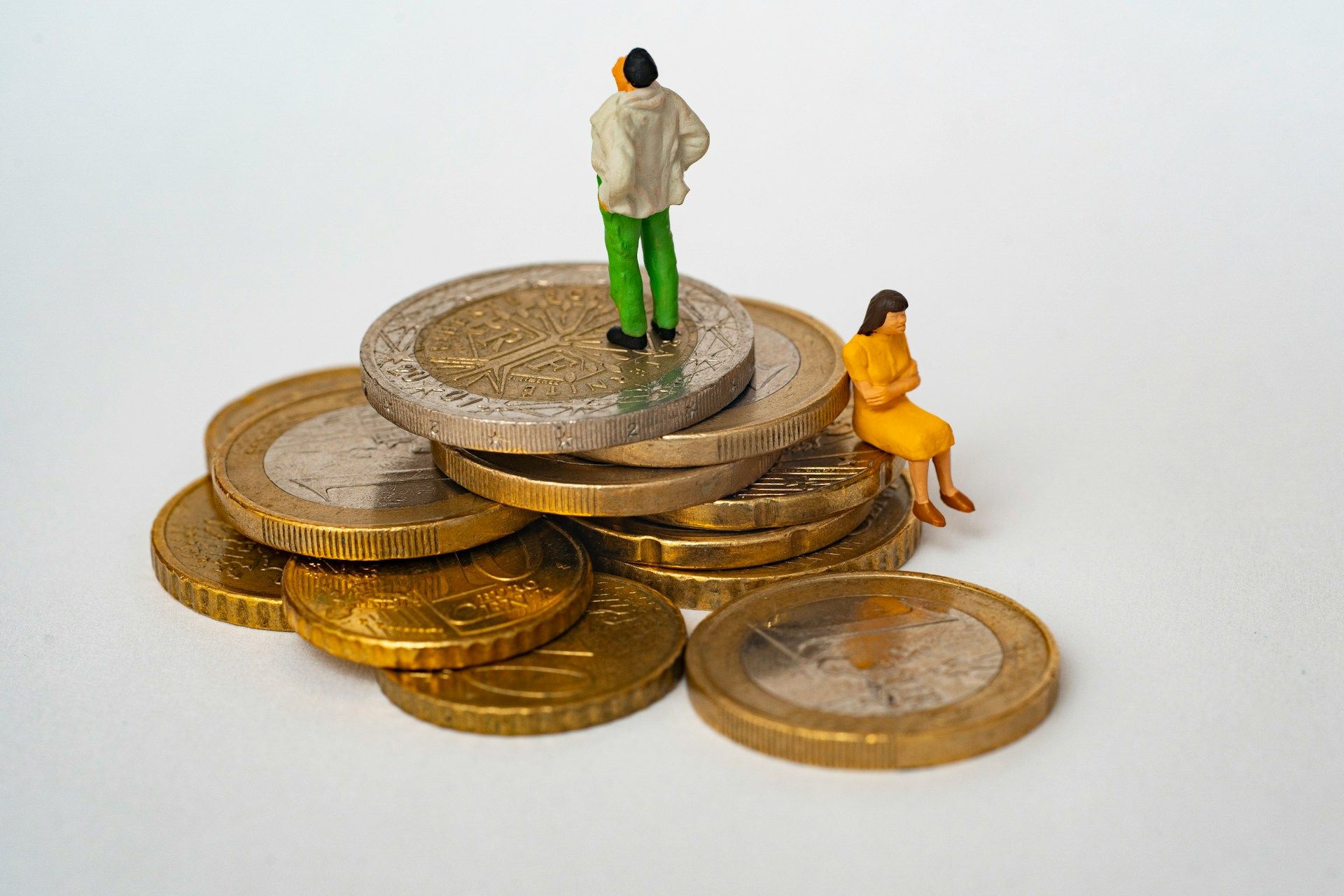 small model people stood on top of some coins